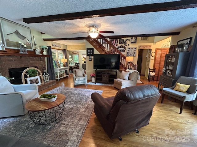2815 Penny Park Dr, Gastonia, NC 28052 - living room with stairway, a textured ceiling, wood finished floors, a fireplace, and ceiling fan
