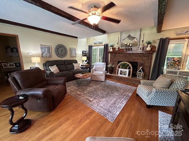 2815 Penny Park Dr, Gastonia, NC 28052 - living room with a textured ceiling, a ceiling fan, wood finished floors, a fireplace, and beam ceiling