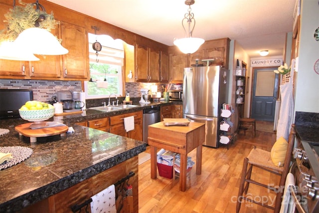 2815 Penny Park Dr, Gastonia, NC 28052 - kitchen featuring stainless steel appliances, tile countertops, a sink, brown cabinetry, and pendant lighting