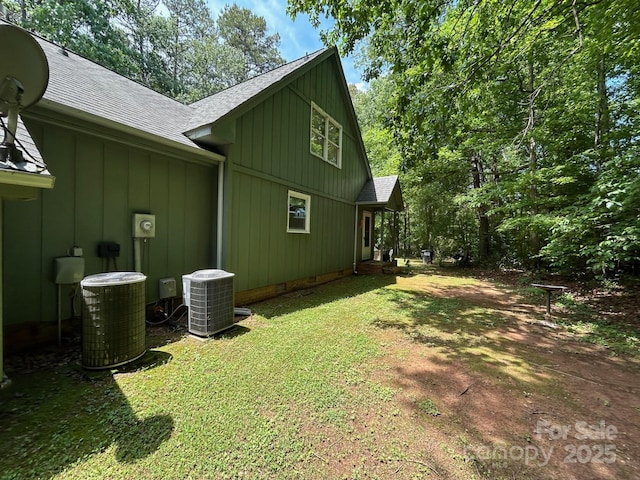 2815 Penny Park Dr, Gastonia, NC 28052 - view of home's exterior with a shingled roof, central air condition unit, board and batten siding, and a yard
