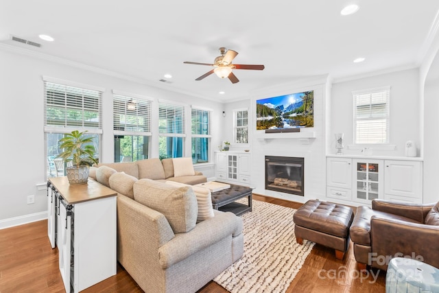 3918 Halcyon Dr, Huntersville, NC 28078 - living room featuring ceiling fan, ornamental molding, wood finished floors, recessed lighting, and a glass covered fireplace