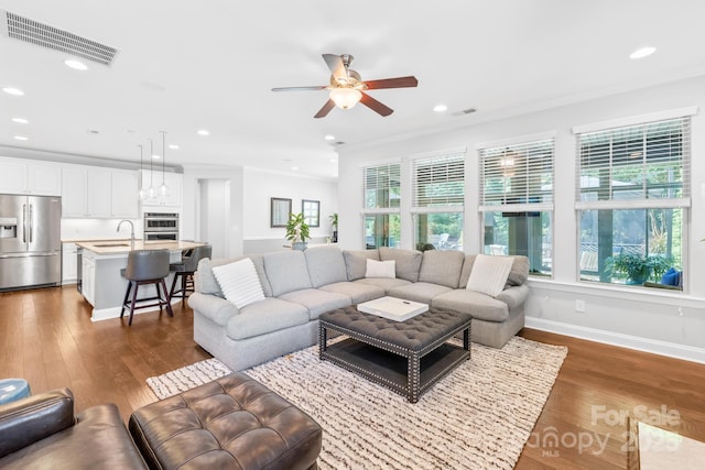 3918 Halcyon Dr, Huntersville, NC 28078 - living room with dark wood-type flooring, a ceiling fan, crown molding, recessed lighting, and baseboards