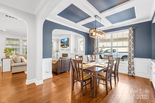 3918 Halcyon Dr, Huntersville, NC 28078 - dining space featuring arched walkways, hardwood / wood-style floors, a chandelier, a wainscoted wall, and healthy amount of natural light