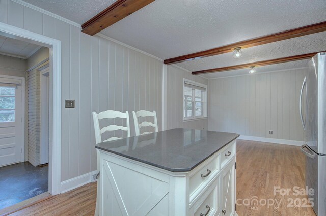 3951 Whitehall Dr, Charlotte, NC 28208 - kitchen with freestanding refrigerator, beam ceiling, plenty of natural light, light wood-type flooring, and a textured ceiling