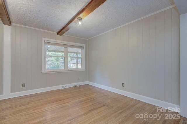 3951 Whitehall Dr, Charlotte, NC 28208 - empty room with light wood-type flooring, a textured ceiling, baseboards, crown molding, and wood walls