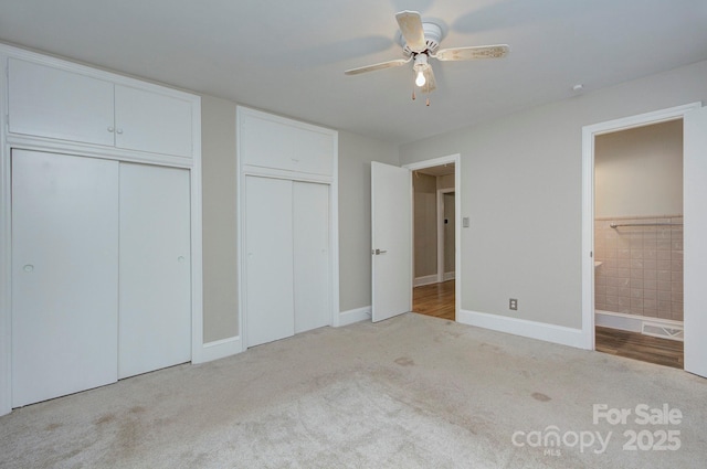 3951 Whitehall Dr, Charlotte, NC 28208 - unfurnished bedroom with carpet floors, two closets, ensuite bath, baseboards, and ceiling fan