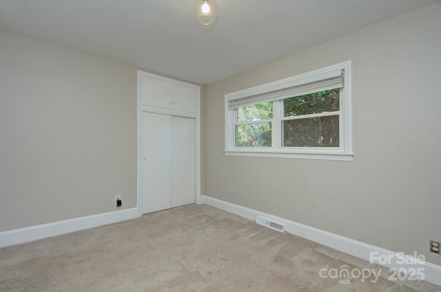 3951 Whitehall Dr, Charlotte, NC 28208 - unfurnished bedroom featuring light colored carpet, baseboards, and a closet