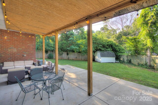3951 Whitehall Dr, Charlotte, NC 28208 - view of patio featuring an outdoor hangout area, a storage unit, and an outbuilding