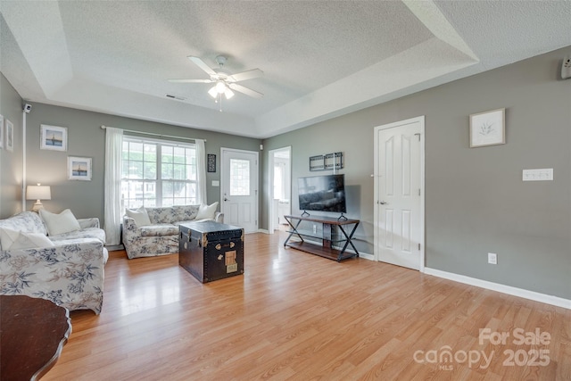 2023 E Park Dr, Lancaster, SC 29720 - living area with a raised ceiling, a textured ceiling, a ceiling fan, light wood finished floors, and baseboards