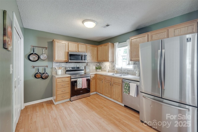 2023 E Park Dr, Lancaster, SC 29720 - kitchen featuring stainless steel appliances, a sink, light brown cabinetry, and a textured ceiling