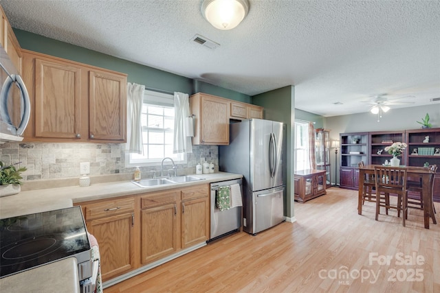 2023 E Park Dr, Lancaster, SC 29720 - kitchen featuring appliances with stainless steel finishes, a sink, light wood-style floors, a textured ceiling, and backsplash