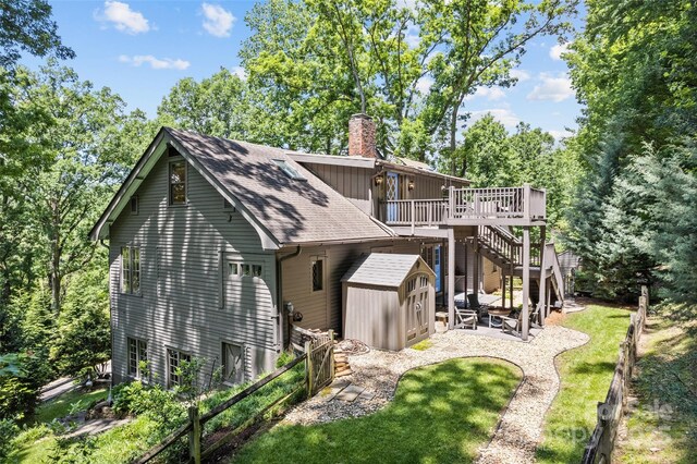 66 Fox Trot Ln, Tryon, NC 28782 - rear view of house featuring a chimney, a shed, a deck, stairway, and a patio area
