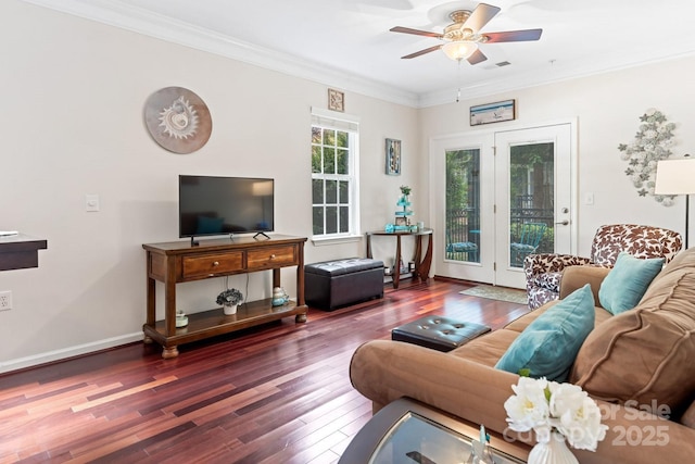 living room featuring hardwood / wood-style floors, ornamental molding, a ceiling fan, and baseboards