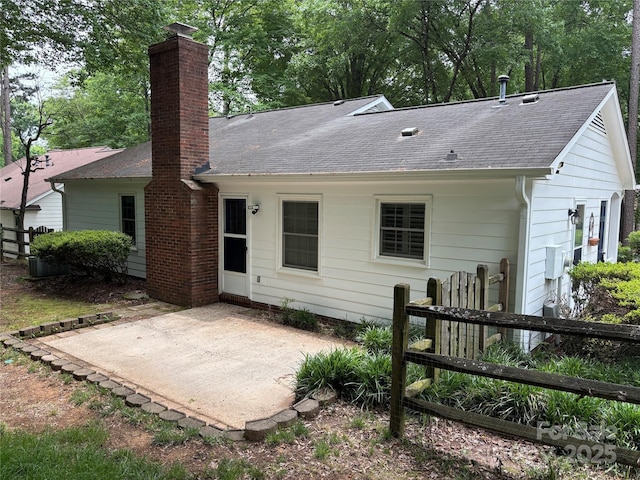 7212 Bradley Ct, Charlotte, NC 28227 - rear view of house with a patio, roof with shingles, fence, and a chimney