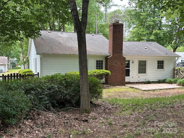 7212 Bradley Ct, Charlotte, NC 28227 - back of house featuring a patio area, a chimney, fence, and roof with shingles