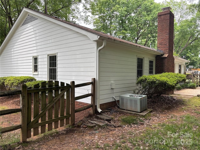 7212 Bradley Ct, Charlotte, NC 28227 - view of side of property with cooling unit, a chimney, fence, and a gate