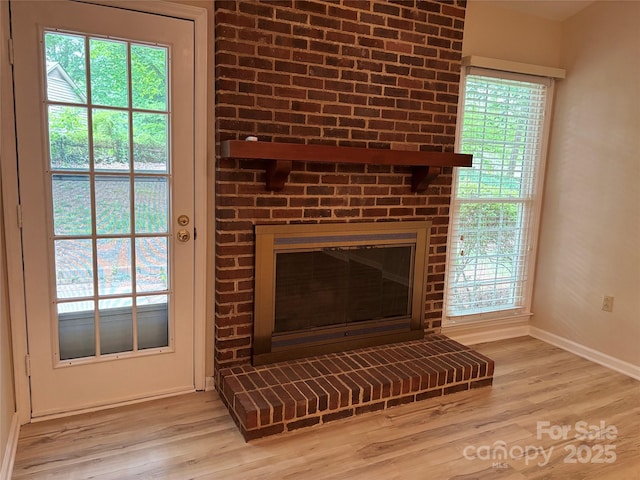 7212 Bradley Ct, Charlotte, NC 28227 - detailed view of baseboards, a brick fireplace, and wood finished floors