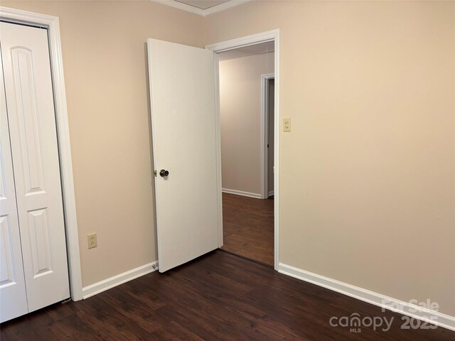 7212 Bradley Ct, Charlotte, NC 28227 - unfurnished bedroom featuring dark wood-style flooring, baseboards, crown molding, and a closet