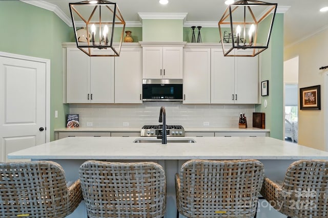 1318 Encore Ln, Waxhaw, NC 28173 - kitchen featuring a chandelier, stainless steel microwave, a sink, backsplash, and ornamental molding