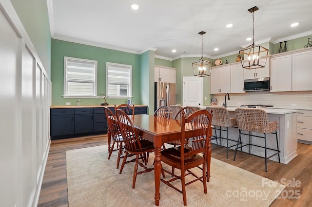 1318 Encore Ln, Waxhaw, NC 28173 - dining area featuring light wood finished floors, recessed lighting, ornamental molding, and a chandelier