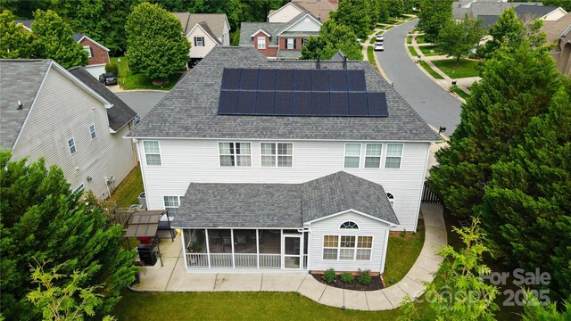 16012 Caranna Ct, Charlotte, NC 28277 - rear view of property featuring a sunroom, roof mounted solar panels, roof with shingles, a yard, and a residential view