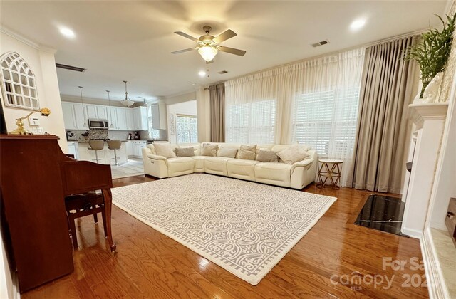 16012 Caranna Ct, Charlotte, NC 28277 - living room with a ceiling fan, wood finished floors, crown molding, and recessed lighting