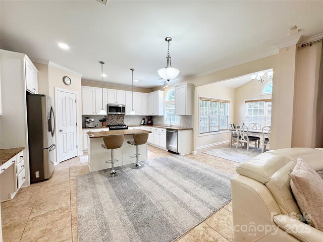 16012 Caranna Ct, Charlotte, NC 28277 - kitchen featuring stainless steel appliances, ornamental molding, backsplash, open floor plan, and white cabinets