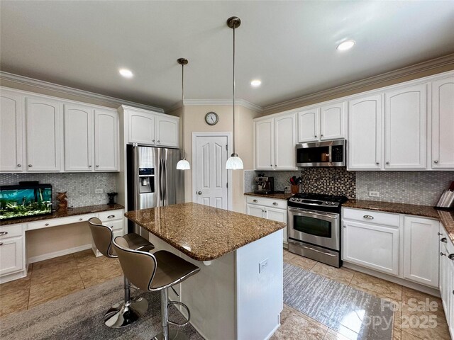 16012 Caranna Ct, Charlotte, NC 28277 - kitchen featuring stainless steel appliances, crown molding, tasteful backsplash, a kitchen bar, and white cabinetry