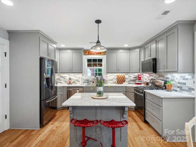 107 Pressley St, Clover, SC 29710 - kitchen featuring appliances with stainless steel finishes, gray cabinetry, tasteful backsplash, light wood-style flooring, and recessed lighting