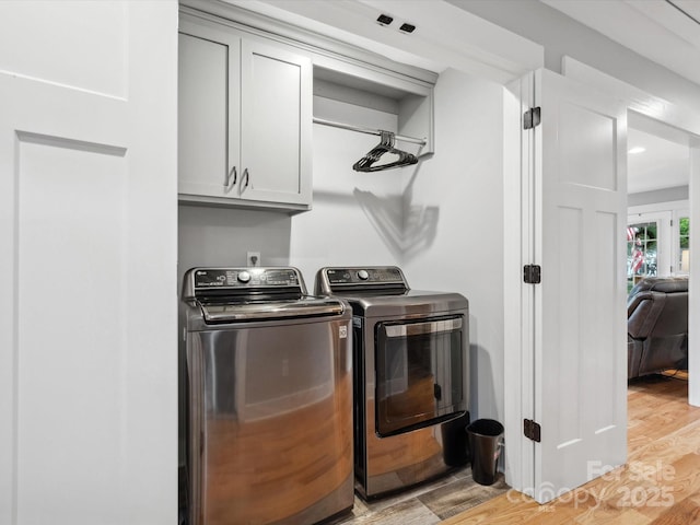 107 Pressley St, Clover, SC 29710 - laundry area with cabinet space, washing machine and clothes dryer, and light wood-style flooring