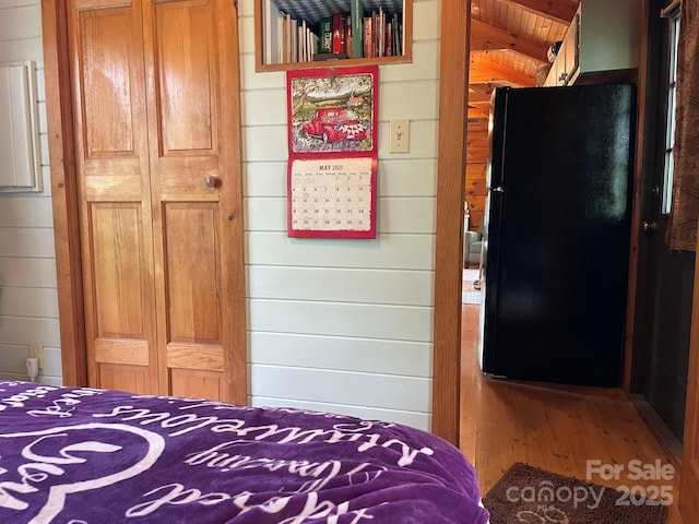 36 Luther Franklin Ln, Newland, NC 28657 - bedroom with freestanding refrigerator, wooden walls, wood finished floors, and a closet