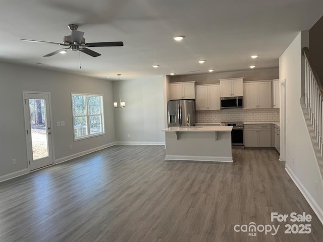 2924 Noritake Trl Unit 67, Albemarle, NC 28001 - kitchen with stainless steel appliances, open floor plan, light countertops, dark wood finished floors, and a kitchen island with sink