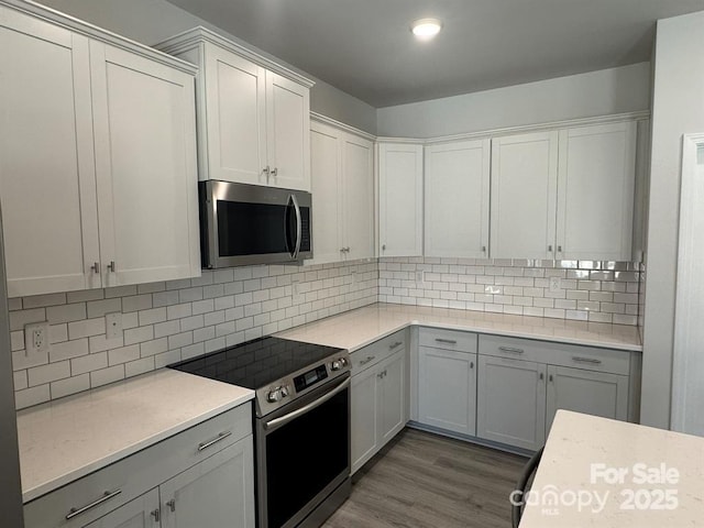 2924 Noritake Trl Unit 67, Albemarle, NC 28001 - kitchen featuring stainless steel appliances, wood finished floors, backsplash, and white cabinetry
