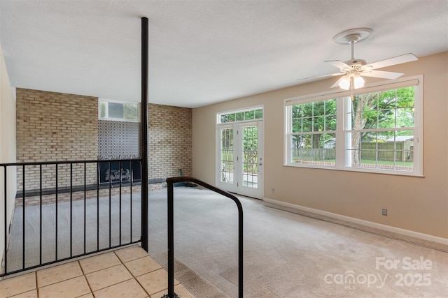 467 16th Ave NW, Hickory, NC 28601 - carpeted empty room featuring plenty of natural light, ceiling fan, baseboards, a textured ceiling, and brick wall