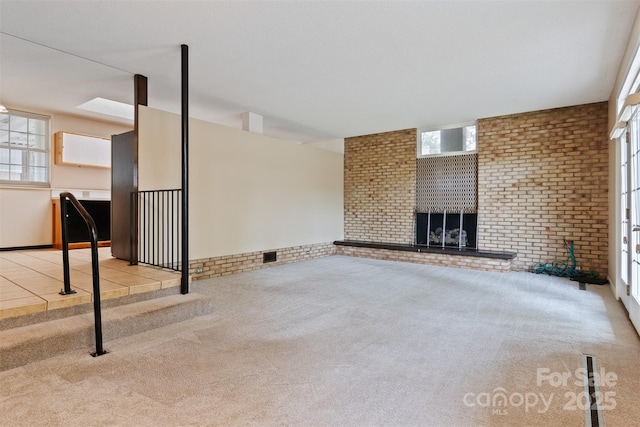 467 16th Ave NW, Hickory, NC 28601 - unfurnished living room with carpet, brick wall, and a fireplace