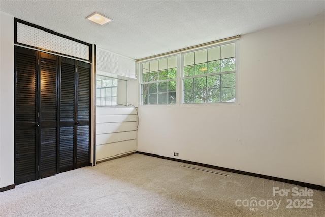 467 16th Ave NW, Hickory, NC 28601 - unfurnished bedroom with carpet, a closet, a textured ceiling, and baseboards