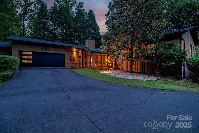6119 Bittersweet Ln, Charlotte, NC 28270 - mid-century modern home with a garage, asphalt driveway, a chimney, and fence