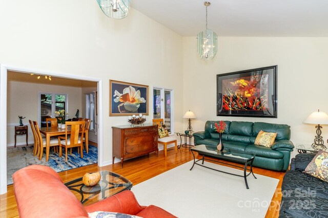 6119 Bittersweet Ln, Charlotte, NC 28270 - living room featuring a chandelier, wood finished floors, and high vaulted ceiling