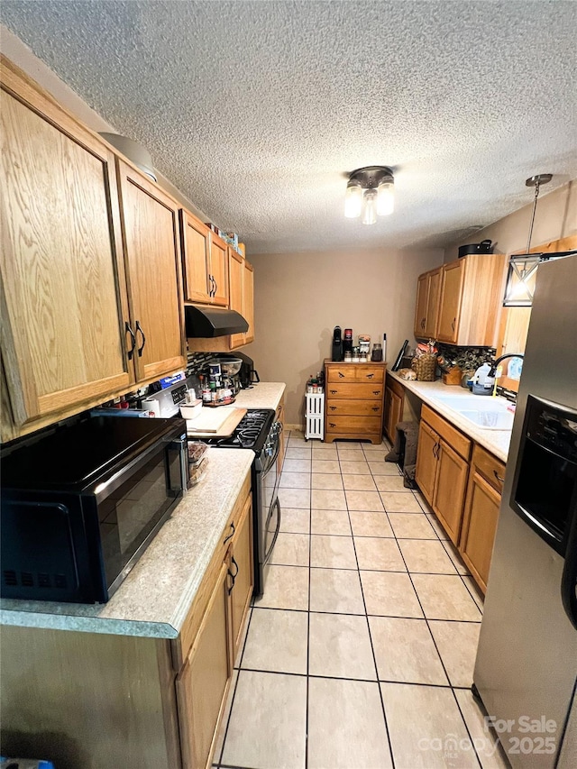 99 Boone St, Spruce Pine, NC 28777 - kitchen with under cabinet range hood, gas stove, light countertops, light tile patterned flooring, and stainless steel fridge with ice dispenser