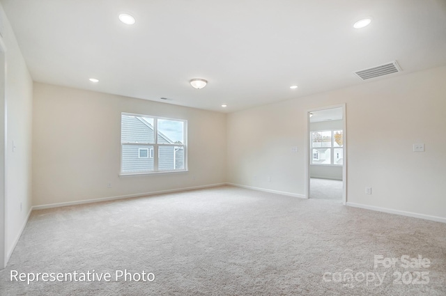 unfurnished room with light colored carpet, baseboards, and recessed lighting