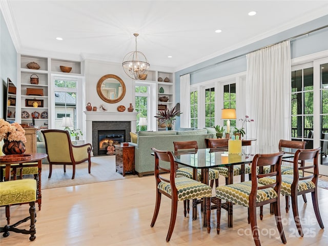 63 Chantilly Dr, Asheville, NC 28804 - dining space with crown molding, built in shelves, plenty of natural light, light wood finished floors, and a chandelier
