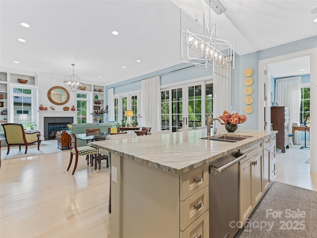 63 Chantilly Dr, Asheville, NC 28804 - kitchen featuring a sink, a chandelier, stainless steel dishwasher, a center island with sink, and light stone countertops