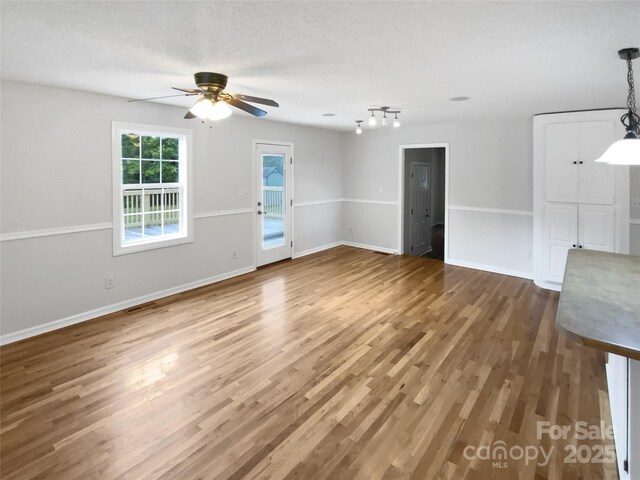 7308 Pleasant Hill Church Rd, Marshville, NC 28103 - unfurnished living room with a ceiling fan, wood finished floors, baseboards, and track lighting