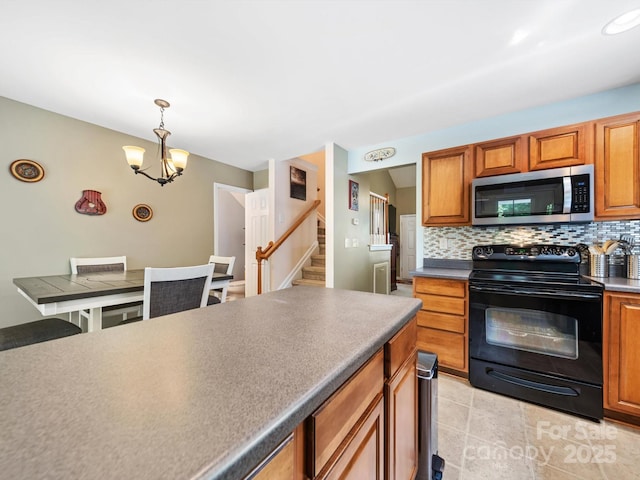3446 Broadwick St, Charlotte, NC 28213 - kitchen with stainless steel microwave, electric range, backsplash, and a chandelier