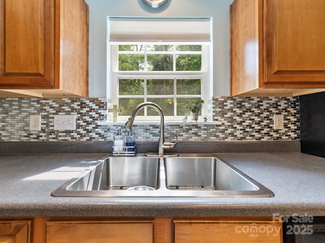 3446 Broadwick St, Charlotte, NC 28213 - kitchen with a sink, dark countertops, brown cabinets, and tasteful backsplash