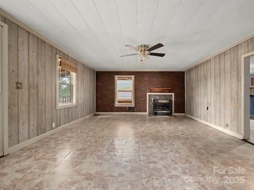 751 Ted Smith Rd, Rutherfordton, NC 28139 - unfurnished living room with wood walls, a ceiling fan, baseboards, and a fireplace