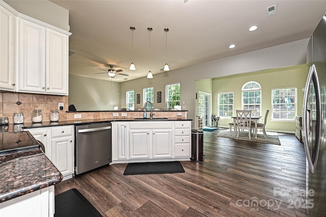 4018 Harmattan Dr, Denver, NC 28037 - kitchen with stainless steel appliances, a sink, a peninsula, dark wood-type flooring, and white cabinetry