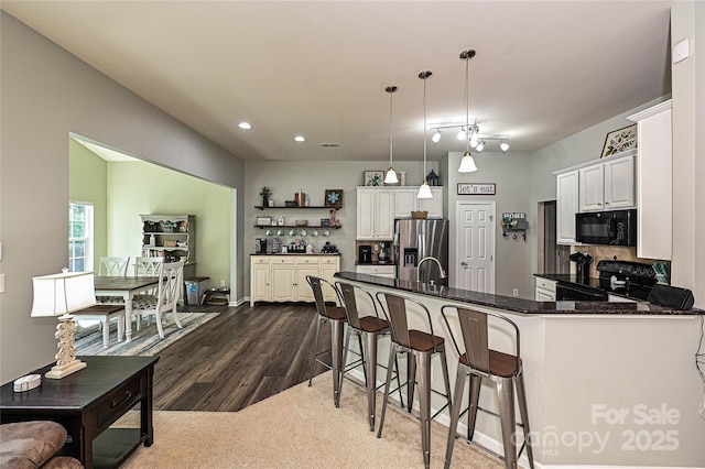 4018 Harmattan Dr, Denver, NC 28037 - kitchen featuring black appliances, open shelves, dark wood finished floors, pendant lighting, and a kitchen breakfast bar