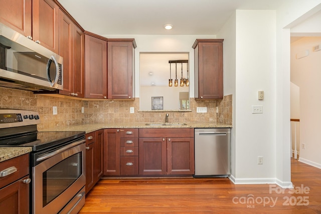 243 Lincoln St, Charlotte, NC 28203 - kitchen featuring appliances with stainless steel finishes, a sink, light stone counters, tasteful backsplash, and recessed lighting