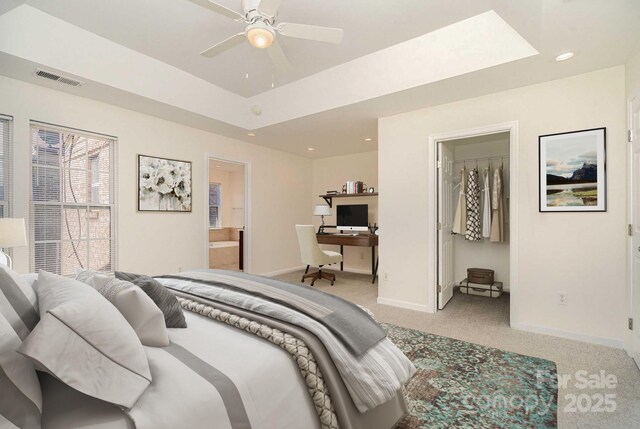 243 Lincoln St, Charlotte, NC 28203 - carpeted bedroom featuring a spacious closet, a desk, baseboards, a tray ceiling, and ensuite bath